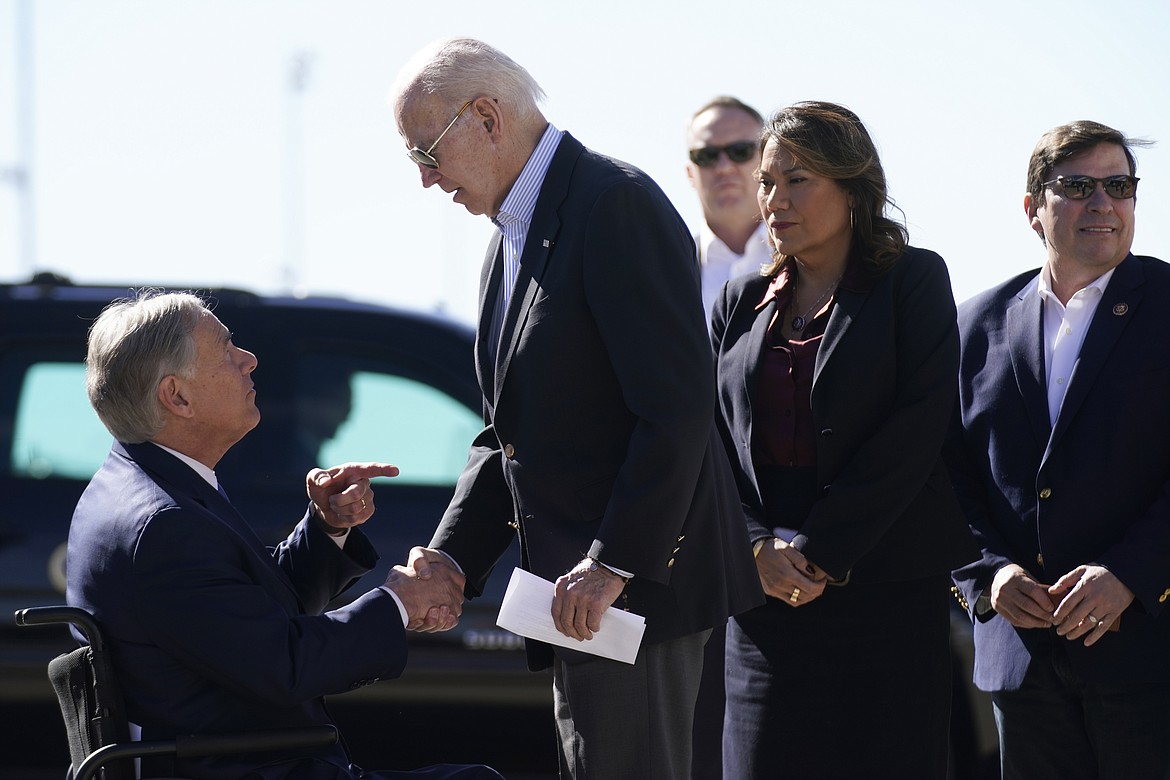 President Joe Biden shakes hands with Texas Gov. Greg Abbott after Abbott handed him a letter about the border at El Paso International Airport in El Paso Texas, Sunday, Jan. 8, 2023. Rep. Veronica Escobar, D-Texas, second from left, and Rep. Vicente Gonzalez Jr., D-Texas, right, look on. (AP Photo/Andrew Harnik)