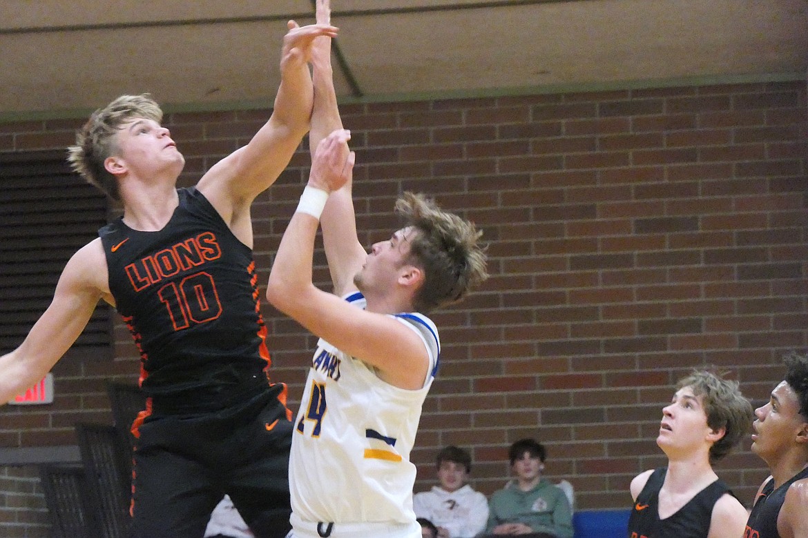 Eureka's 6-5 center Braden Casazza (10) contests a shot attempt by 6-4 Blue Hawks forward Jesse Claridge (24) in the Lions last-second win over Thompson Falls Saturday evening. (Chuck Bandel/VP-MI)