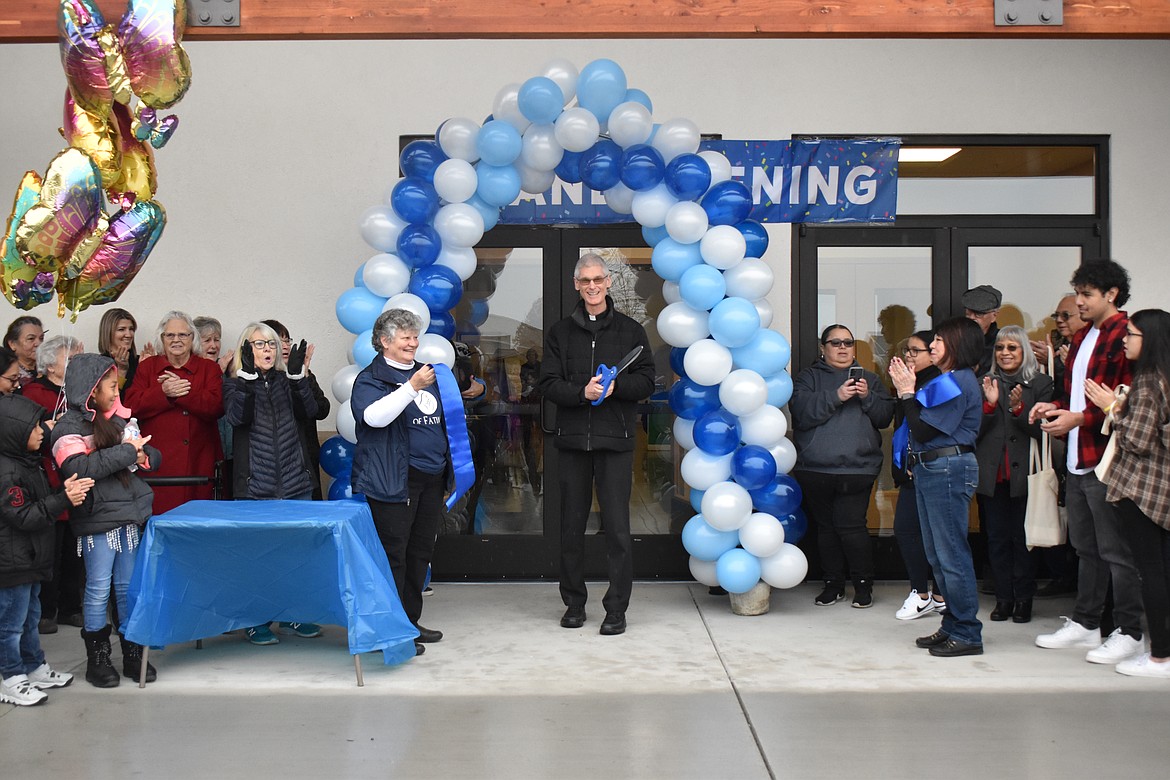 Father Daniel Dufner smiles as he cuts the ribbon to the new Fatima Center, located at 210 N. Dale Road, Moses Lake.