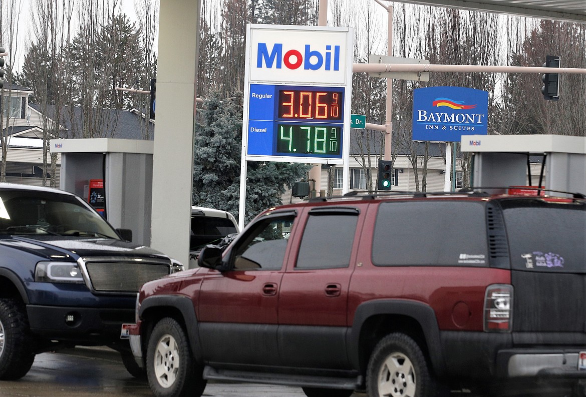 Vehicles line up at the pumps for fuel Monday at a Sherman Avenue station. While the cost of gas jumped up at some stations in Coeur d'Alene, they held steady in most and remain around $3 a gallon.