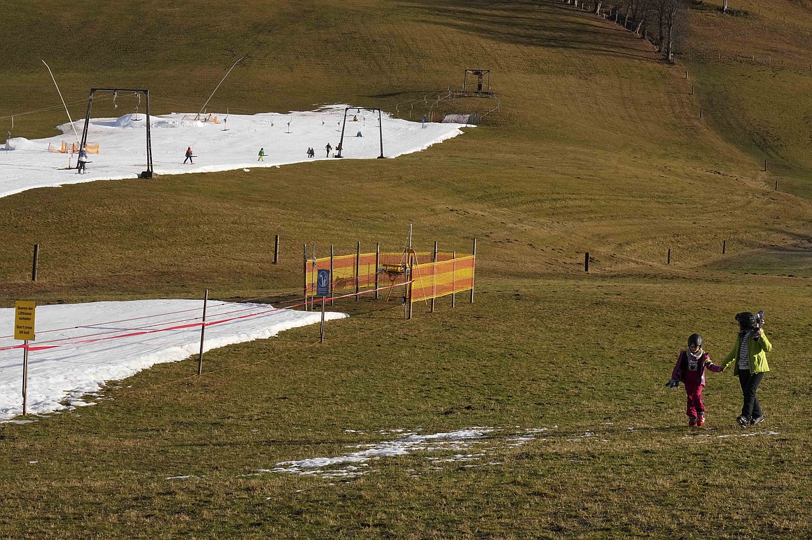 FILE - People walk across a slope in Filzmoos, Austria, on Jan. 6, 2023. Europe has dodged an energy apocalypse this winter, economists and officials say, thanks to unusually warm weather and efforts to find other sources of natural gas after Russia cut off most of its supply to the continent. (AP Photo/Matthias Schrader, File)