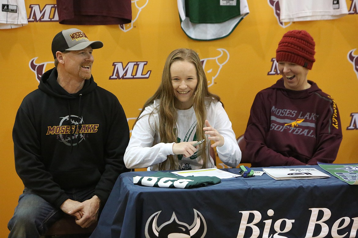 Ali Stanley, center, smiles after signing on to play collegiate softball at Big Bend Community College on Monday afternoon.