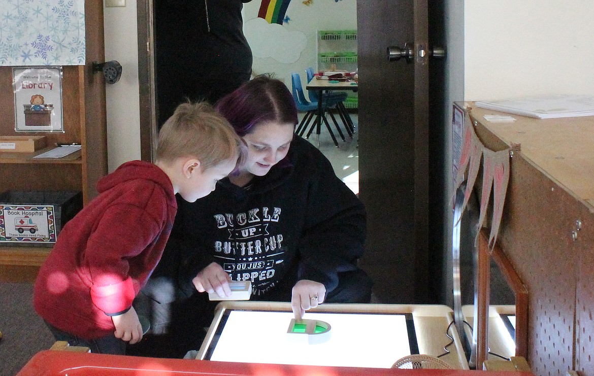 Three-and-a-half-year-old Alexander Luther, left, and his mom Stephanie Luther play and learn on a light table at the Big Bend C-oop Preschool’s new location at Immanuel Lutheran Church. The school operates on the principle that children learn best by playing.