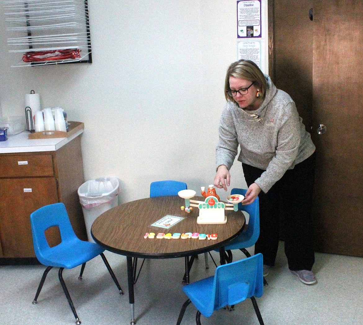 Big Bend Cooperative Preschool teacher Stephanie Gregg shows the math center at the school’s new home at Immanuel Lutheran Church. On one side of the scale kids can put a weight shaped like a number, whose weight matches that number of smaller weights on the other side. This approach teaches kids number concepts more smoothly than mere memorization, Gregg said.