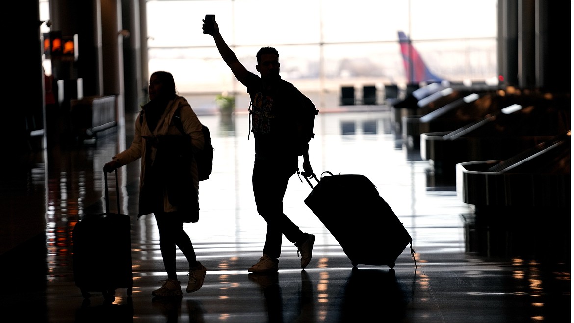 People pass through Salt Lake City International Airport, Wednesday. The world's largest aircraft fleet was grounded for hours by a cascading outage in a government system that delayed or canceled thousands of flights across the U.S.