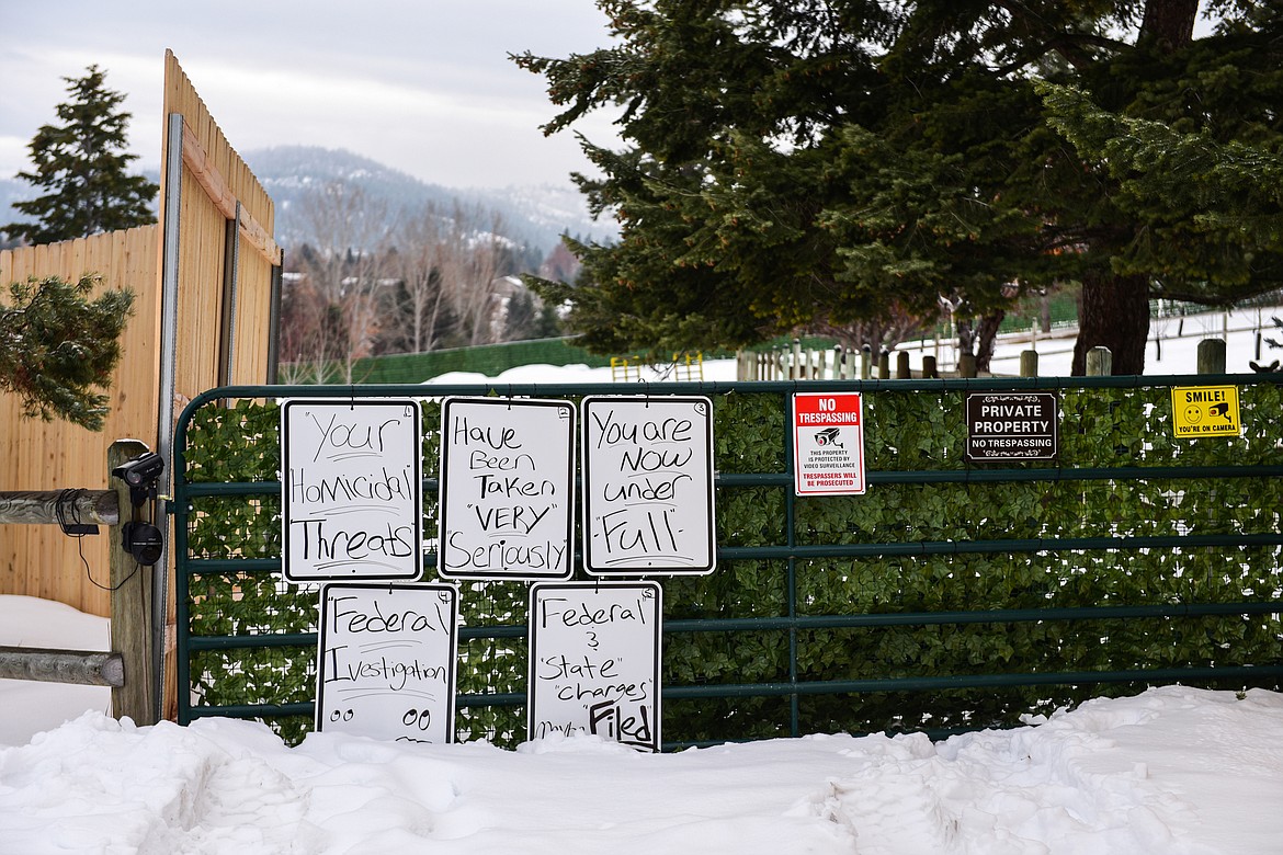 Handwritten signs along a portion of a fence on a property along Lake Hills Lane on Thursday, Jan. 12. (Casey Kreider/Daily Inter Lake)