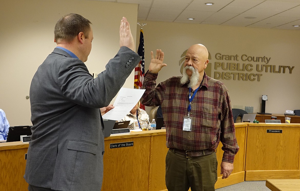 Nelson Cox, right, is sworn in by Grant County Superior Court Judge Tyson Hill for a second term on the Grant County PUD commission.