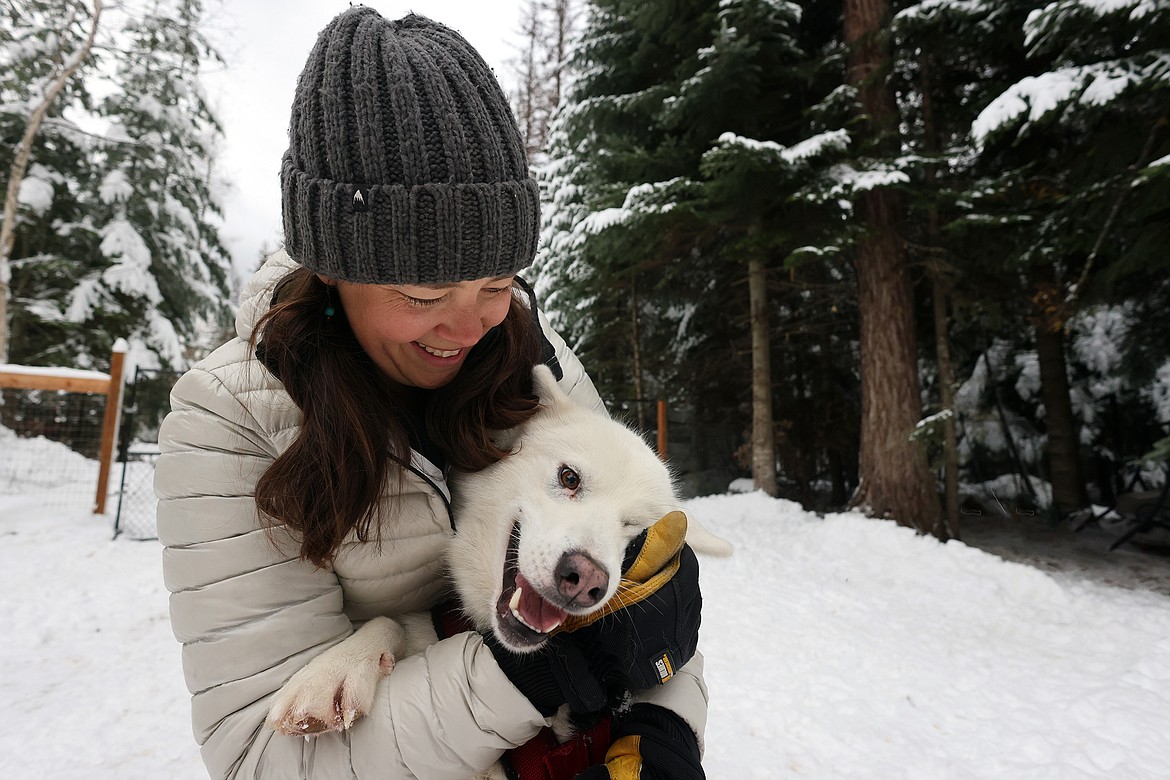 Basecamp Bigfork Owner Sam Schurke plays with one of their sled dogs on Dec. 7, 2022. (Jeremy Weber/Bigfork Eagle)