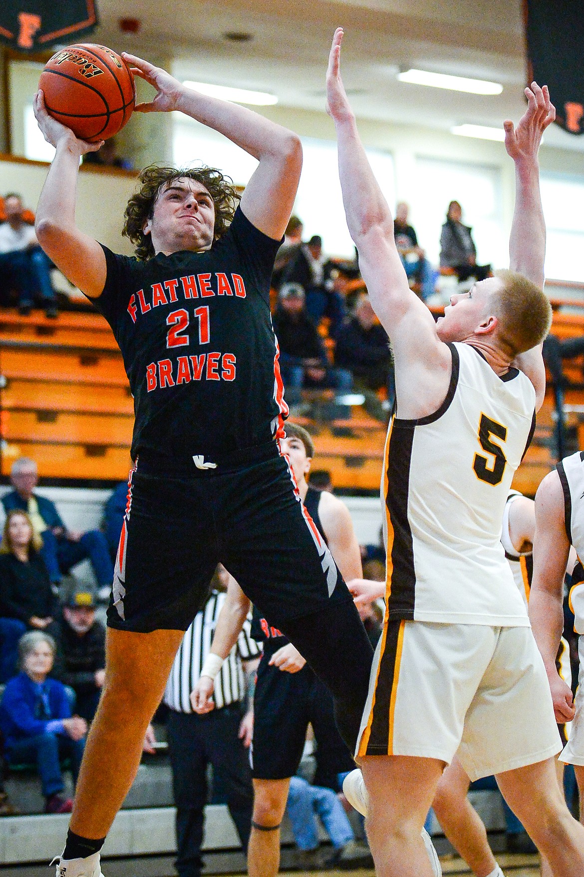 Flathead's Slate Burrington (21) knocks down a shot over Helena Capital's Nick Michelotti (5) in the first half at Flathead High School on Saturday, Jan. 14. (Casey Kreider/Daily Inter Lake)