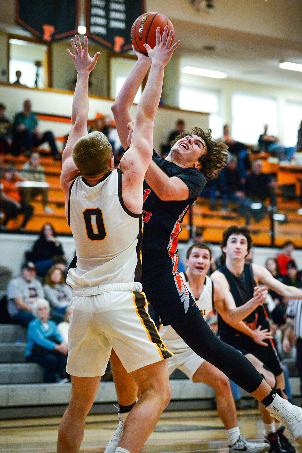 Flathead's Slate Burrington (21) knocks down a shot over Helena Capital's Hayden Opitz (0) in the first half at Flathead High School on Saturday, Jan. 14. (Casey Kreider/Daily Inter Lake)