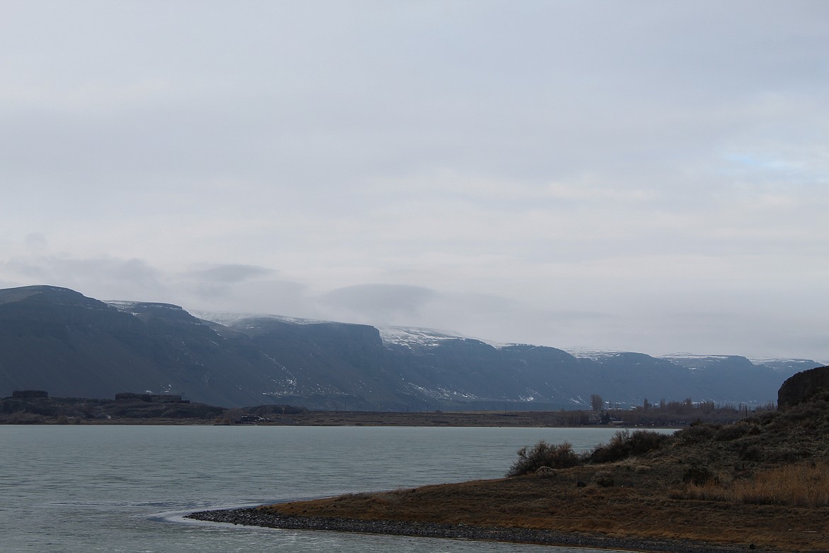 Clouds drape over the snow-dusted rim of the coulee north of Soap Lake Saturday afternoon. Temperatures rose last week causing most of the snow accumulated this winter to melt at lower elevations.