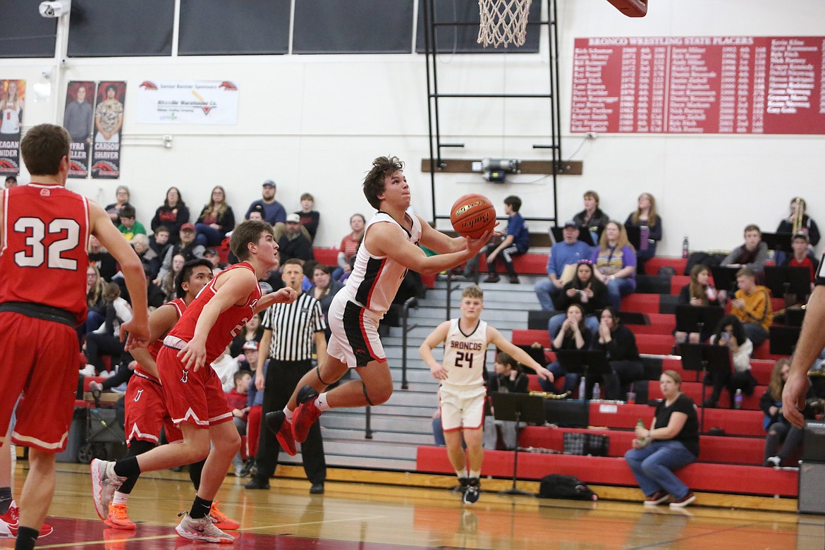 While falling forward, Lind-Ritzville/Sprague senior Hunter Dinkins looks to hit a layup during the second quarter of the Bronco’s loss to Davenport on Saturday.