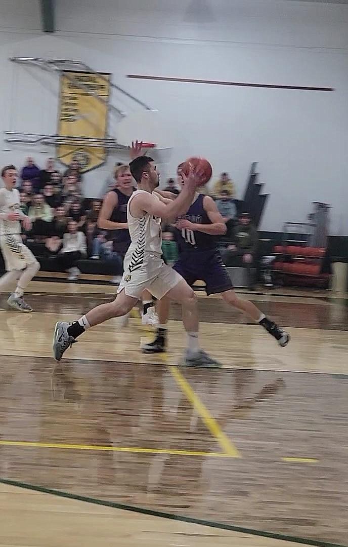 St. Regis senior Caleb Ball drives past a Charlo defender Saturday night during a game in which broke the school's all-time scoring record.  (Courtesy photo)