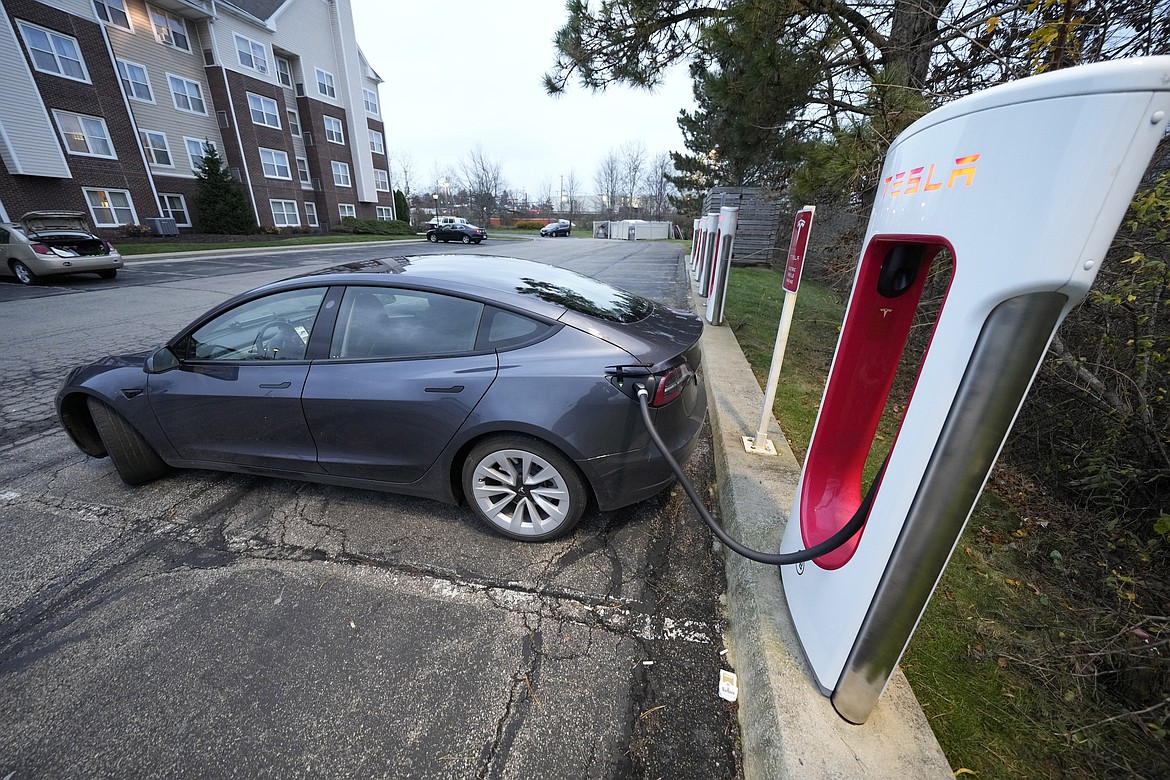 FILE - A Tesla sedan gets a charge at a Tesla Supercharging station in Cranberry, Pa, Wednesday, Nov. 16, 2022. With its sales slowing and its stock price tumbling, Tesla Inc. slashed prices dramatically Friday on several versions of its electric vehicles, making some of its models eligible for a new federal tax credit that could help spur buyer interest. (AP Photo/Gene J. Puskar, File)