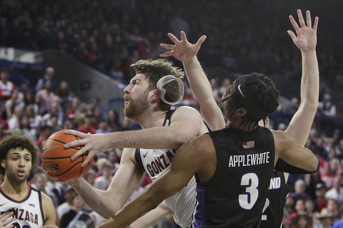 Gonzaga forward Drew Timme drives to the basket while defended by Portland forward Alden Applewhite (3) and guard Tyler Robertson during the first half of an NCAA college basketball game Saturday, Jan. 14, 2023, in Spokane, Wash.