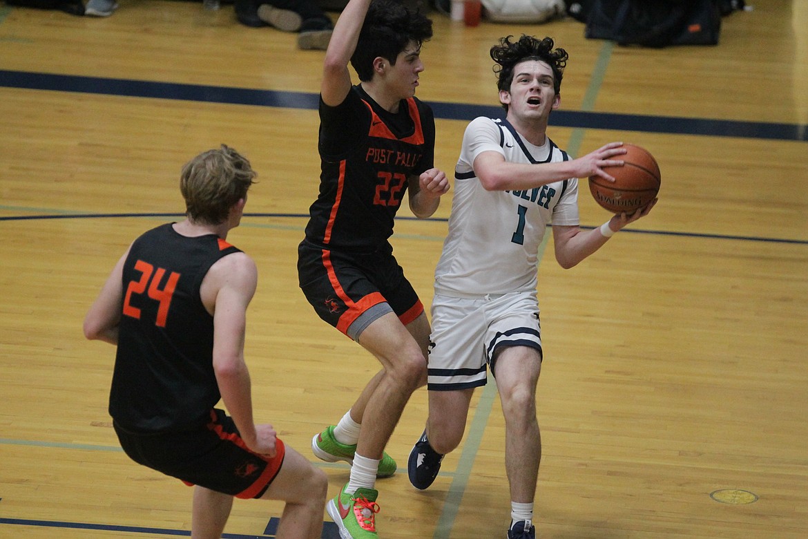 MARK NELKE/Press
Reese Strawn (1) of Lake City drives the baseline against Tyras Blake (22) and Asher Bowie (24) of Post Falls on Tuesday at Lake City. Strawn scored on the drive, and was fouled.