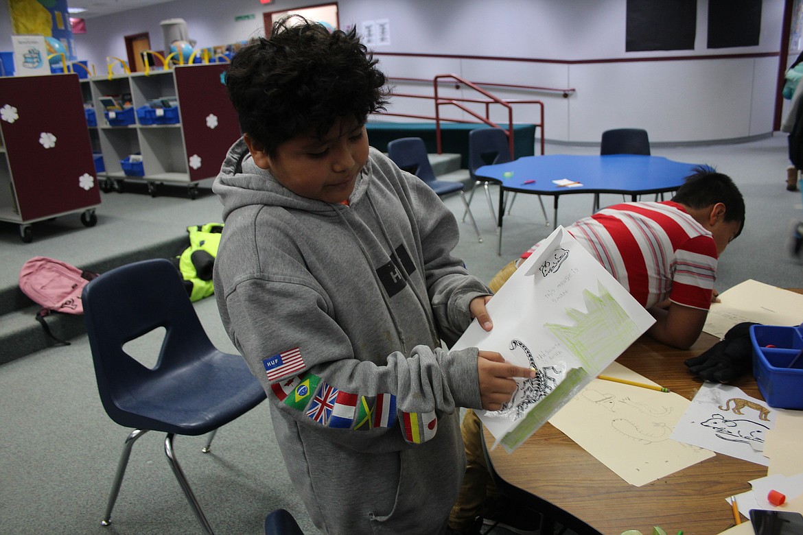 Max Quiroz demonstrates the moveable scorpion in the book on the jungle animals he made during Warrior Academy.