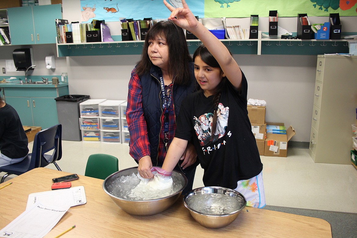 Bridget Saucedo, right, sticks her hand in a plastic bag filled with pretend “blubber” with the help of Wahluke School District teacher Irene Longmire. Saucedo and other students were learning about polar bears during Warrior Academy.