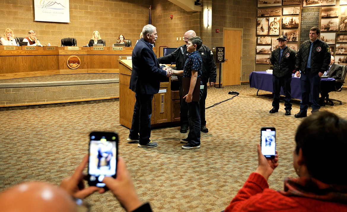 Coeur d'Alene Mayor Jim Hammond shakes the hand of Joree Jimenez as others look on during Tuesday's City Council meeting.