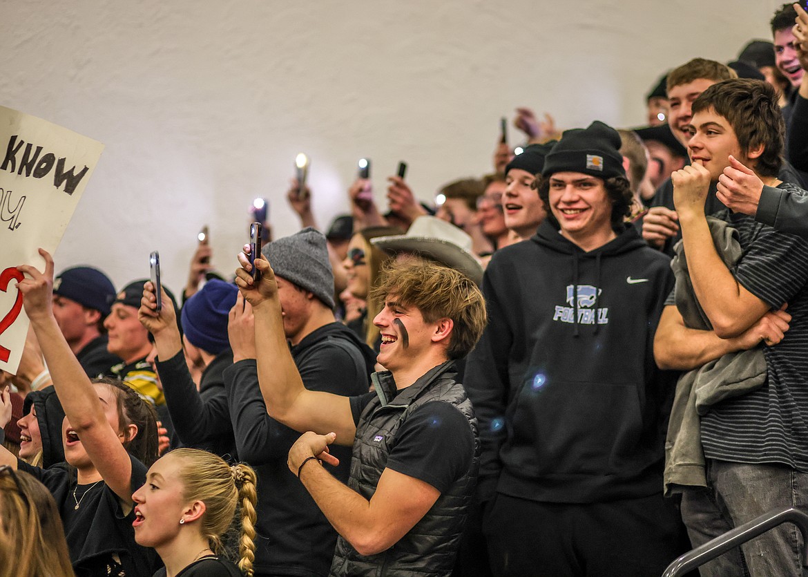 Junior Kai Golan and the Columbia Falls student section get loud and hold up cell phones with flashlights in the final moments of the game against the Bulldogs in Whitefish. (JP Edge photo)