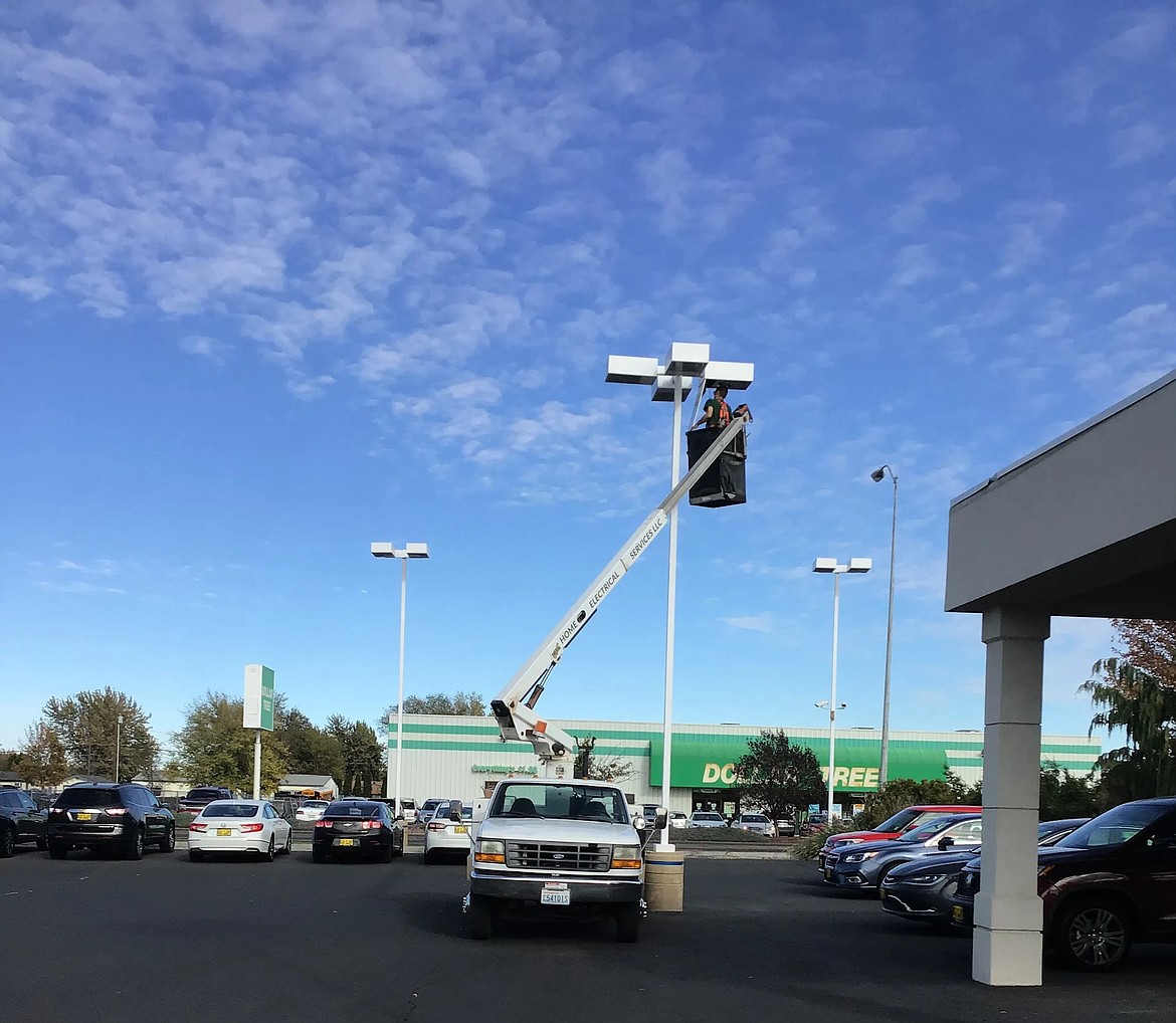 A Home Electrical Services electrician steps up – and up and up – to repair a light.