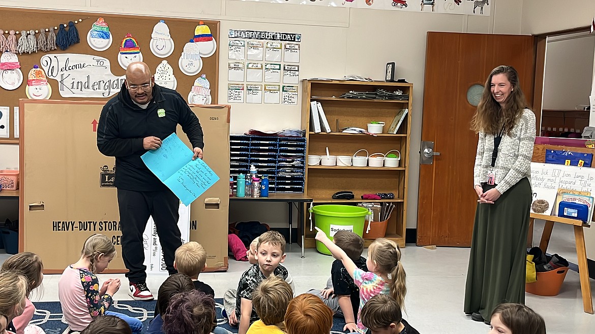 An Idaho Lottery official accepts a thank you card from students in Washington Elementary teacher's Johanna Soderberg kindergarten class after she received a Classroom Wishlist grant to buy three storage cubby systems.
