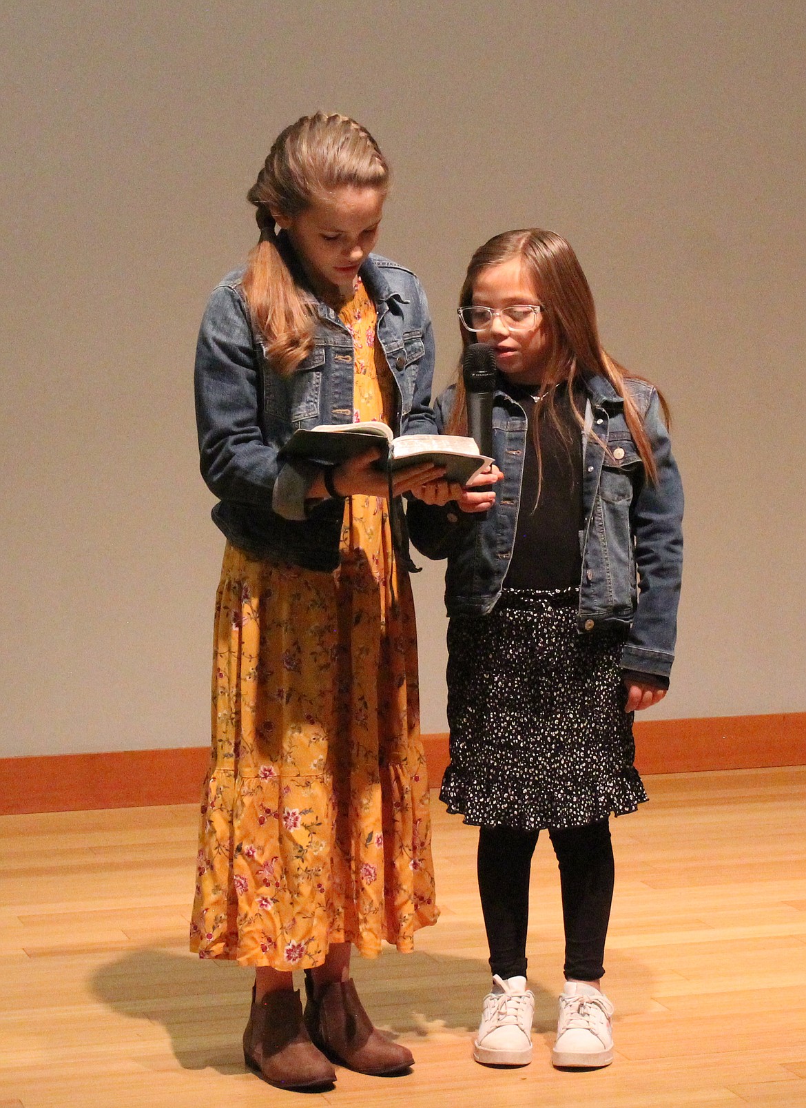 Kassie Trautman, left, and Zoe Chavez read a scripture passage at the Moses Lake Martin Luther King Jr. Day celebration Monday.