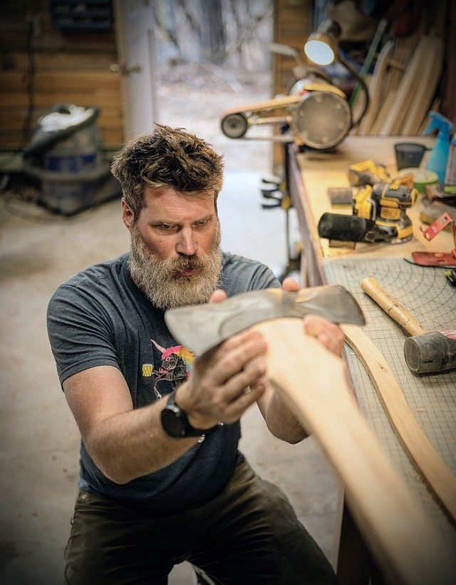 Paul Flannigan of Stumptown Axes works in his shop to fit an axe head with a new handle. (photo provided)