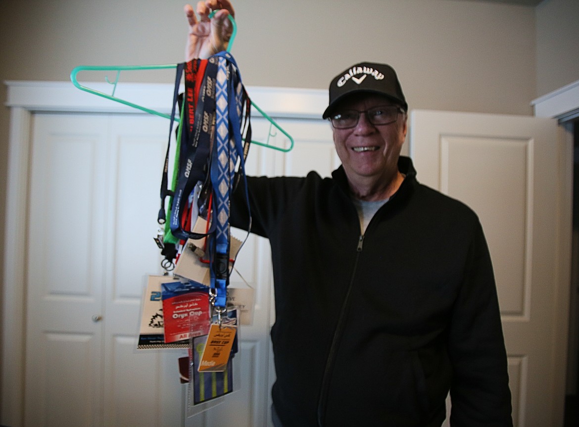 Steve Montgomery on Friday holds up a few of the hydroplane and jet boat pit passes in his collection from his many years as a race announcer. The seasoned radio personality now broadcasts on PureGold Oldies internet radio from his North Idaho home studio.