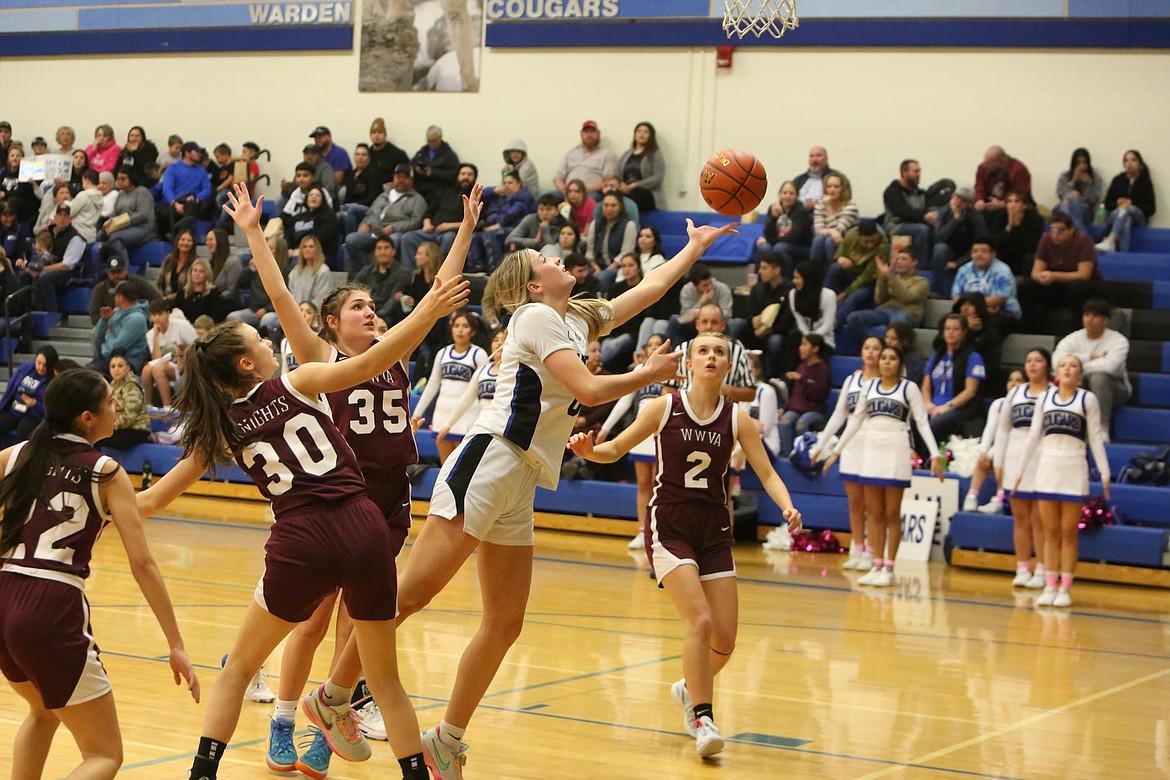 Junior Lauryn Madsen, pictured evading defenders while shooting a layup, led the Cougars with 24 points on Thursday night.