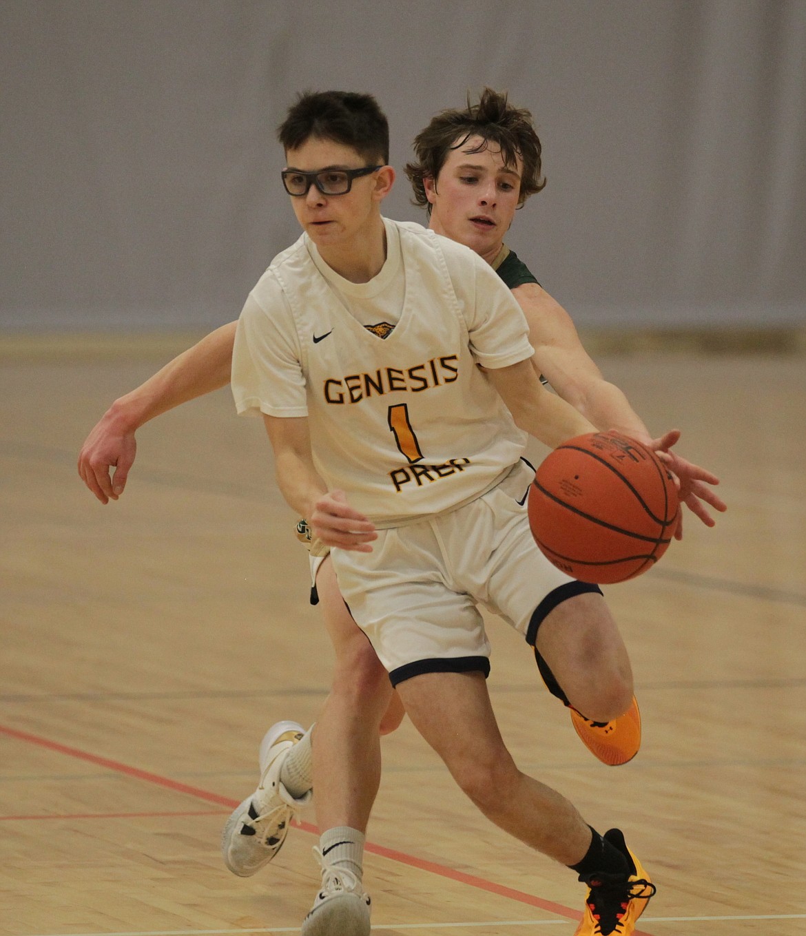 MARK NELKE/Press
Spencer Farrell (1) of Genesis Prep drives to the basket as Jared Badgett of St. Maries reaches on Saturday night at The Courts at Real Life in Post Falls.