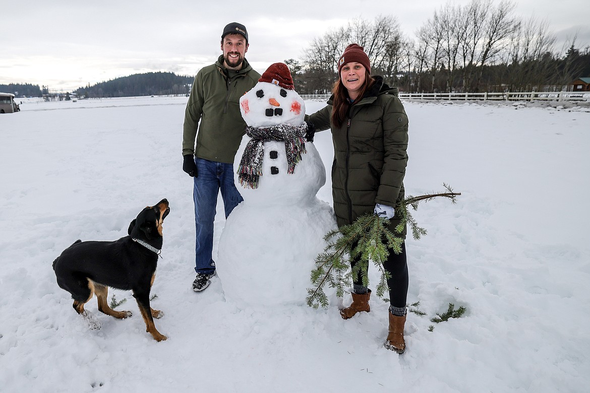 Dan Nesovic and Jillian Gue of Whitefish with their dog Hiccup participate in the snowman building competition at the Springs on Jan. 14, 2023. (JP Edge/Hungry Horse News)