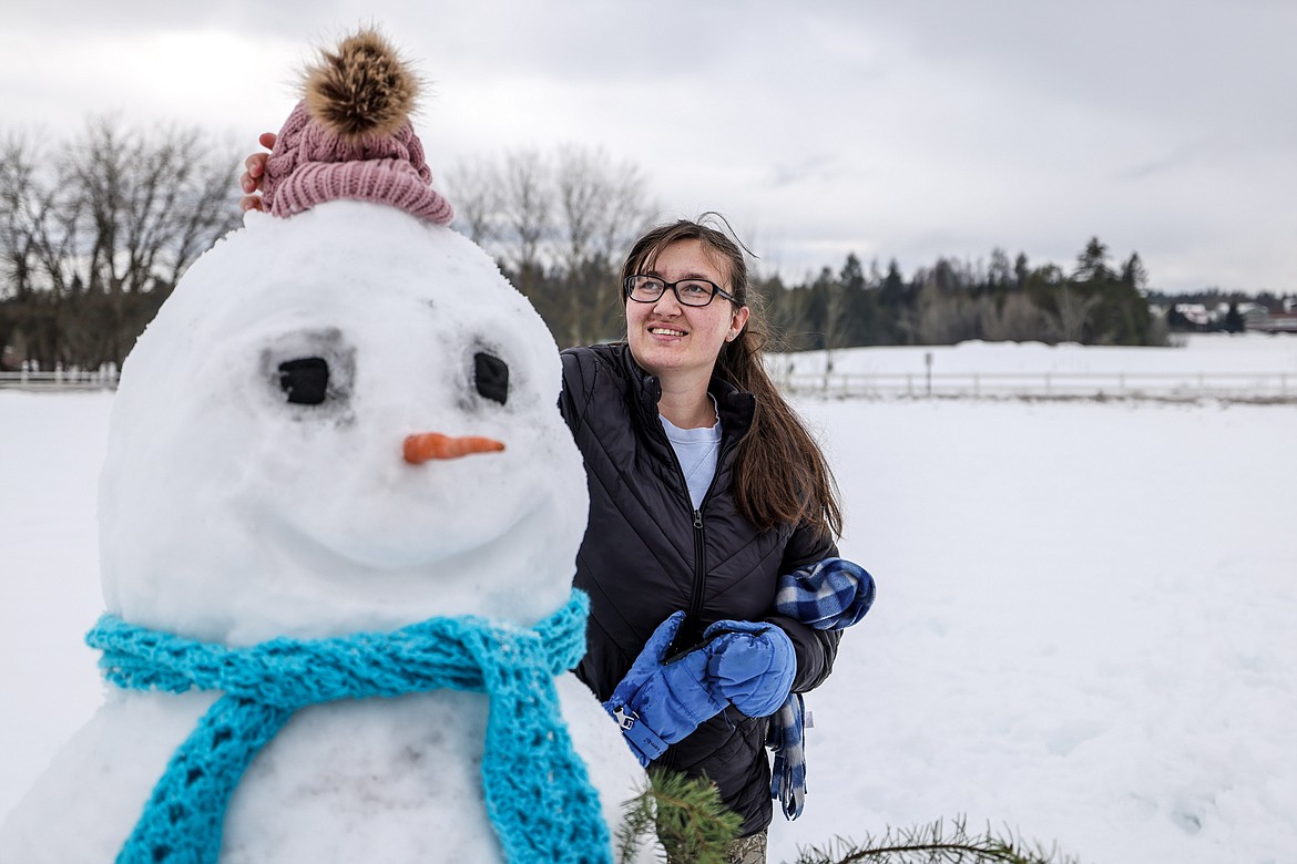 Kati Thomas puts the finishing touches on her family's snowman at the Snowman Building Competition at the Springs in Whitefish on Jan. 14. (JP Edge/Hungry Horse News)