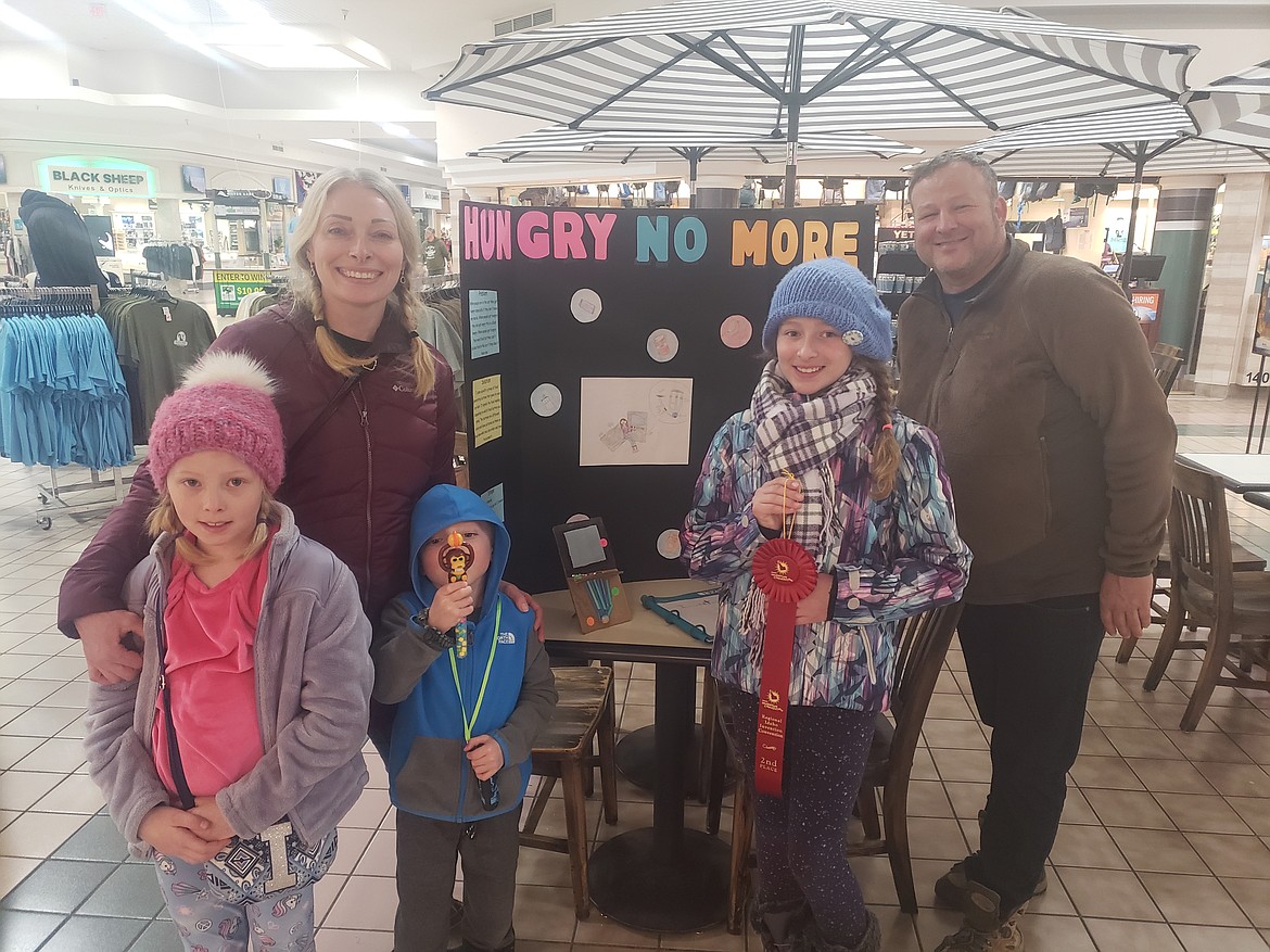 Top Left to right, Christina Sears, her daughter Elle Sears and Husband Chad Sears, pose with the poster board Elle created for the Regional Invent Idaho competition Sunday at Silver Lake Mall.