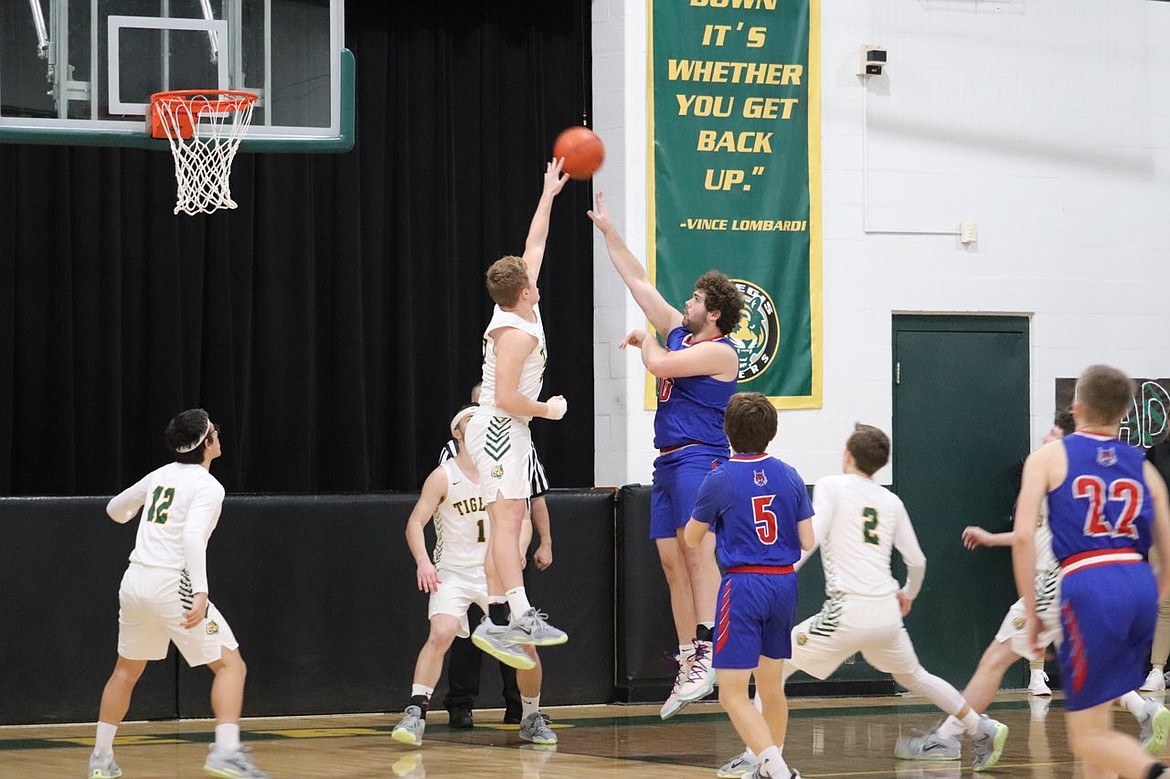 Junior forward John Pruitt (white) goes high to block a shot by Superior post Wyatt Haworth during St. Regis' victory over the Bobcats Friday night in St. Regis.  (Photo by Kami Milender)