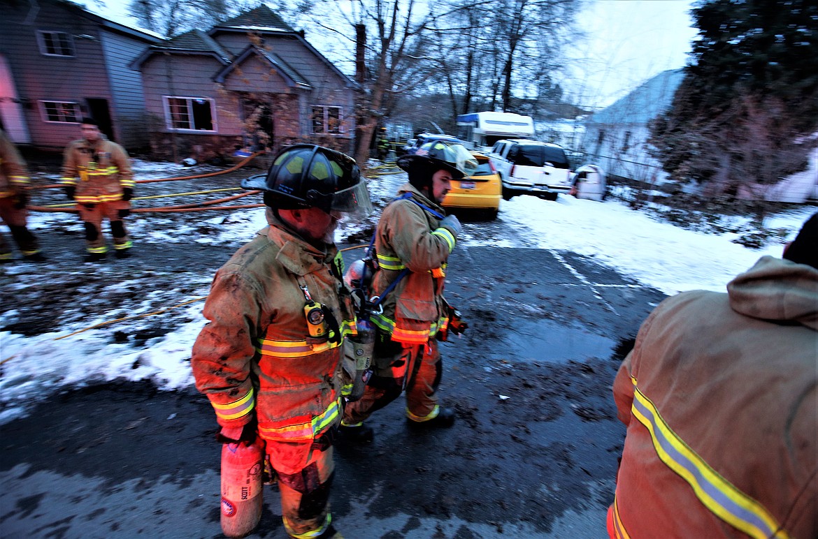 Firefighters begin to clean up following a house fire in the 1500 block of Seventh Street in Coeur d'Alene on Monday.