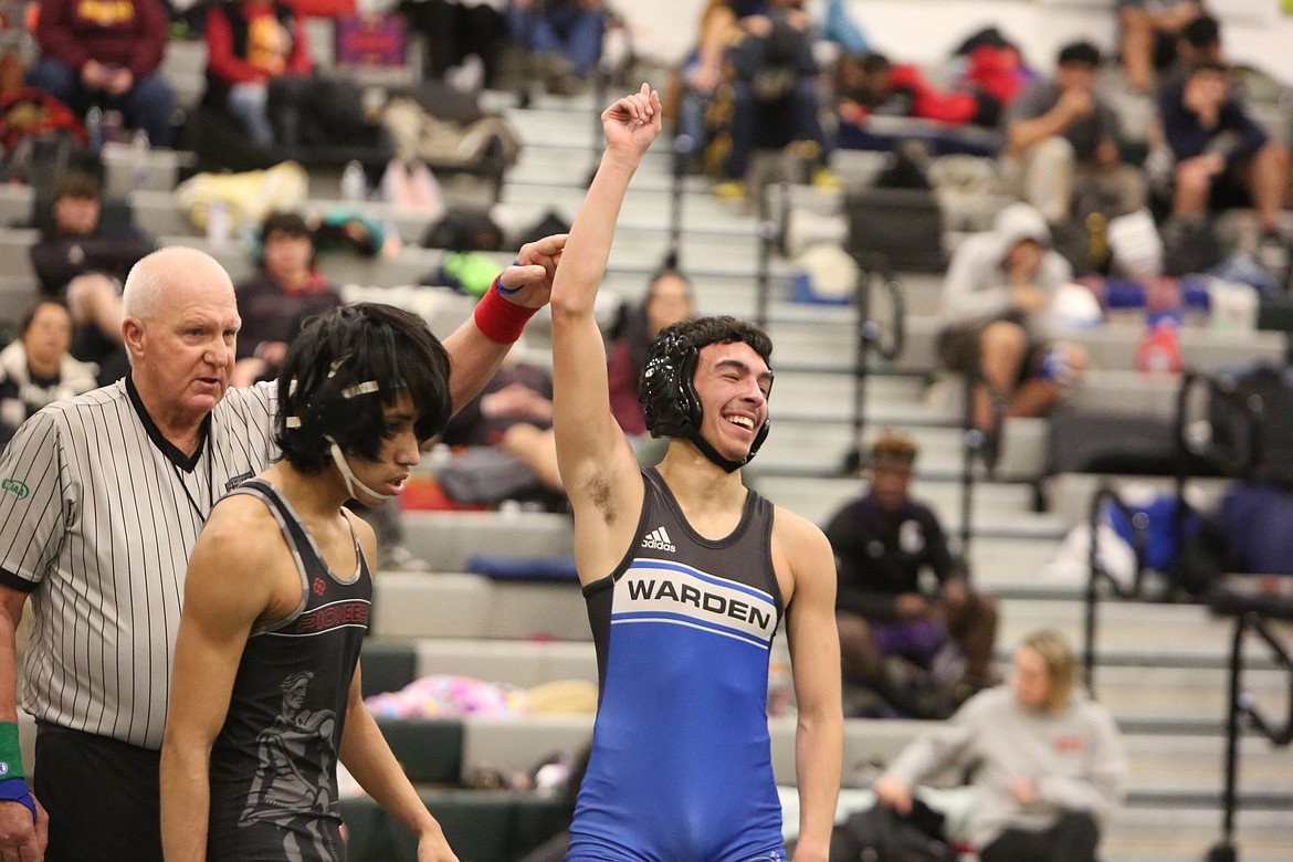 Warden senior Gio Castro, right, smiles after taking down his opponent at the Mat Animal Invitational. Castro placed fourth in the 106 weight class at the tournament.