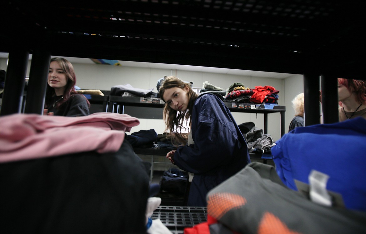 Senior Echoe Stapel on Jan. 24 peeks through the racks of the New Vision Community Clothes Closet. The free, student-led clothing resource is open to the public Tuesdays or by appointment.