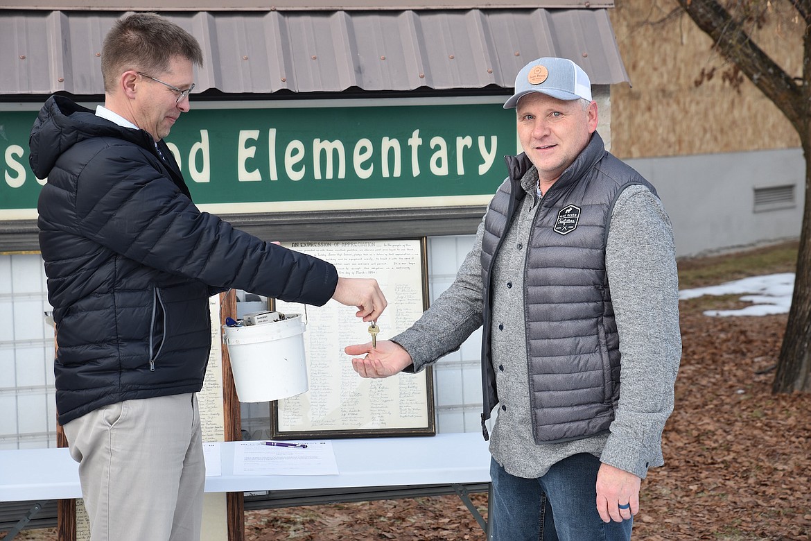Libby Public Schools Superintendent Ron Goodman hands the keys to the former Asa Wood School building Wednesday afternoon to Compass Health CEO and owner Darren Smith. (Scott Shindledecker/The Western News)