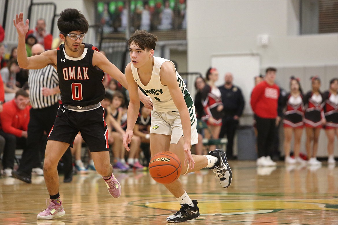 Quincy freshman Pierce Bierlink takes the ball up the floor against the Omak defense in the second half of Tuesday night’s win.