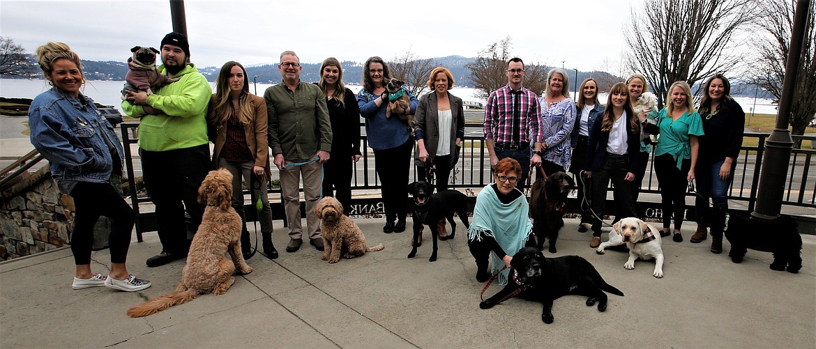 People and dogs gather outside the Coeur d'Alene Regional Chamber on Thursday. From left: Tabitha Kraack-Bonner, Duncan Andersen, Chloe Linton, Mark Robitaille, Emily Boyd, May Lehto, Ellen Crabtree, Skyler Clifton, Ali Shute, Abby Light, Briana Francis, Katie Rose Hargreaves (with the white little dog), Kerri Jensen, Linda Coppess, CEO of the Coeur d’Alene Regional Chamber, and Joan Ford kneeling with Charlie.