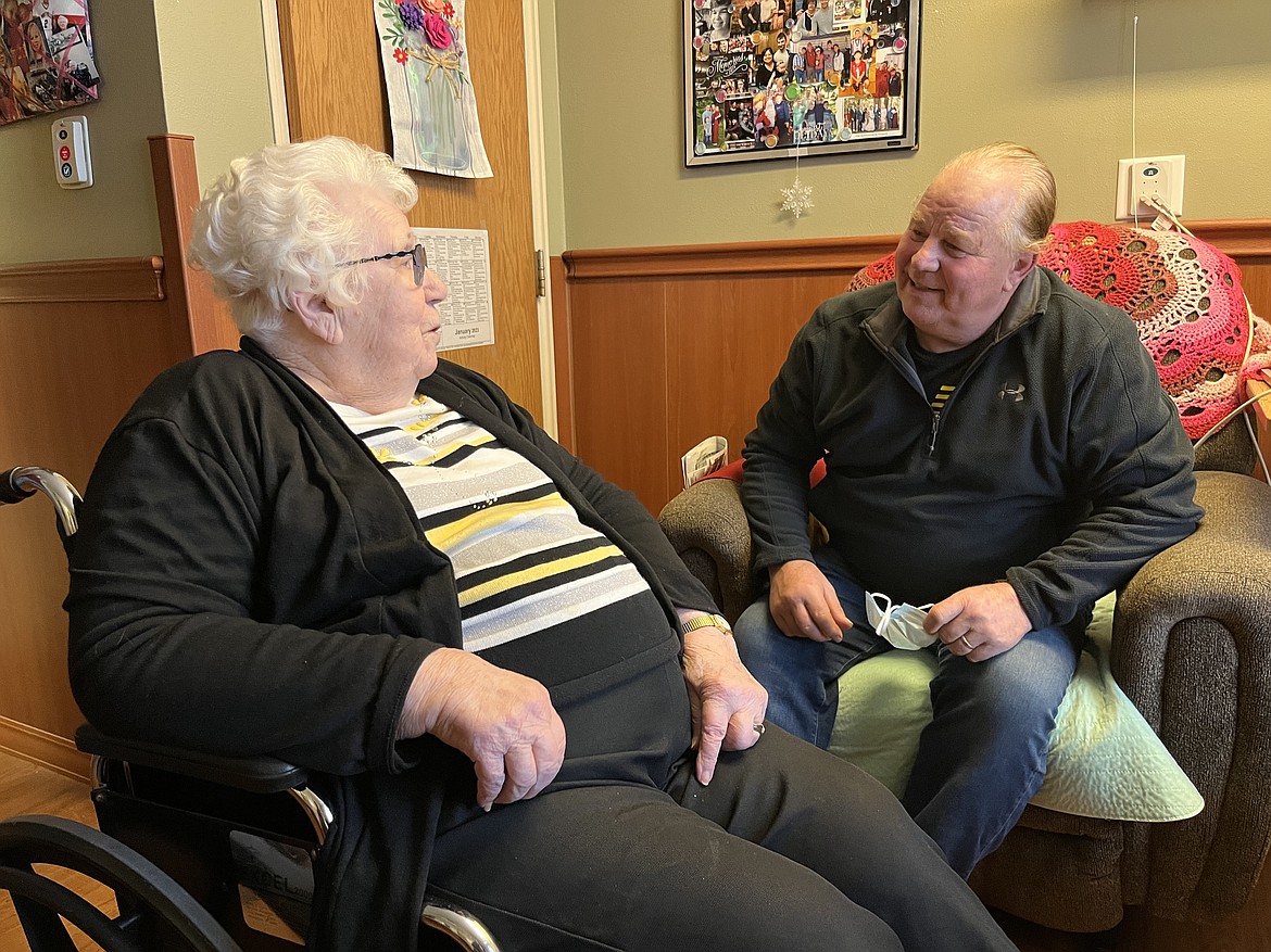 Marjorie Kruger visits with son Dan White in her new room at the Evangelical Lutheran Good Samaritan Society nursing home in Waukon, Iowa. Kruger transferred to the Waukon facility in September 2022, because Good Samaritan was closing its Postville, Iowa, home, where she lived for six
years. (Tony Leys/KHN)