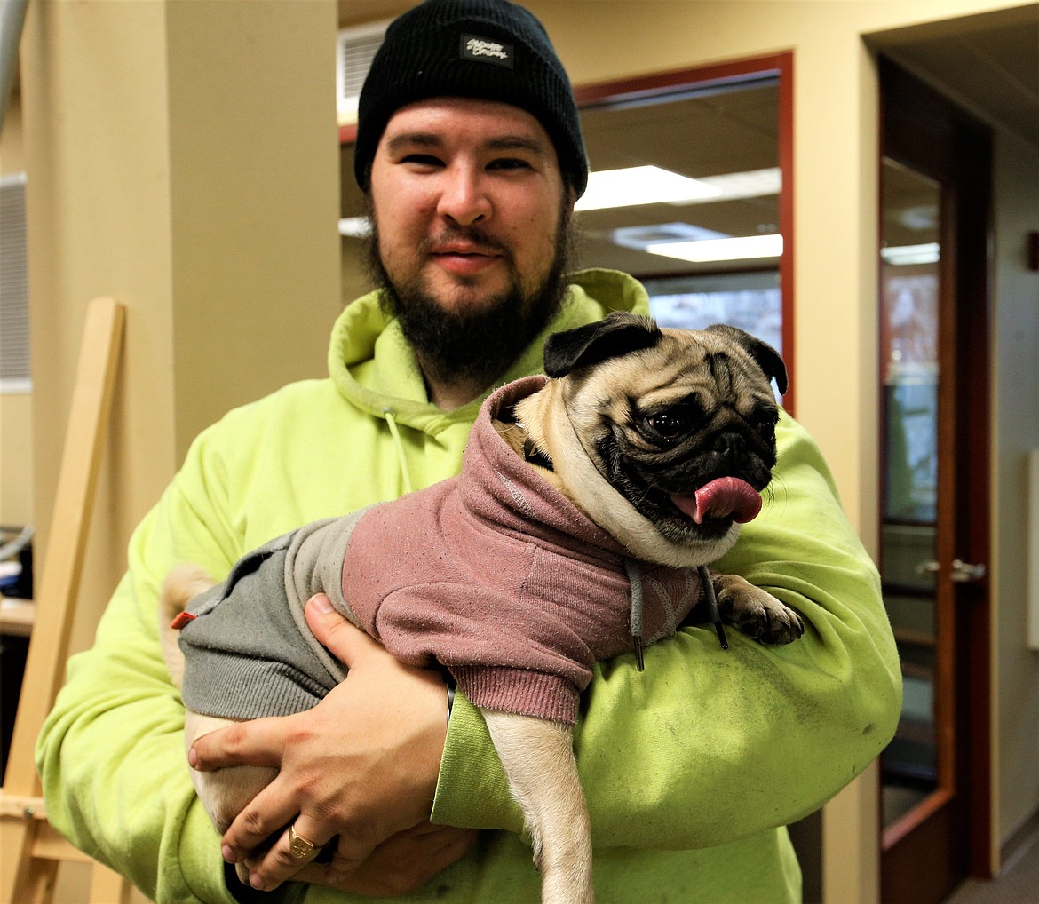Duncan Andersen with the Coeur d'Alene Downtown Association holds Eggsy, a Pug, on Thursday.