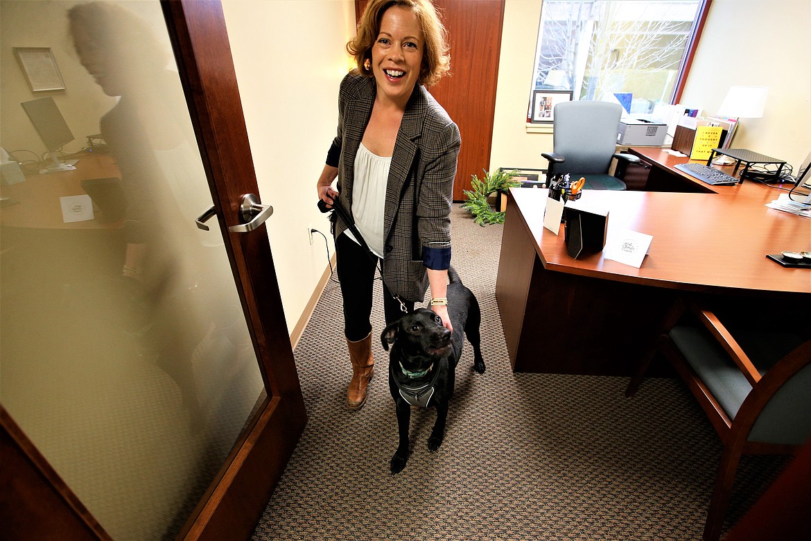 Ellen Crabtree with the Innovia Foundation and Jackson, a Labrador, walk from her office in the Coeur d'Alene Regionall Chamber building.
