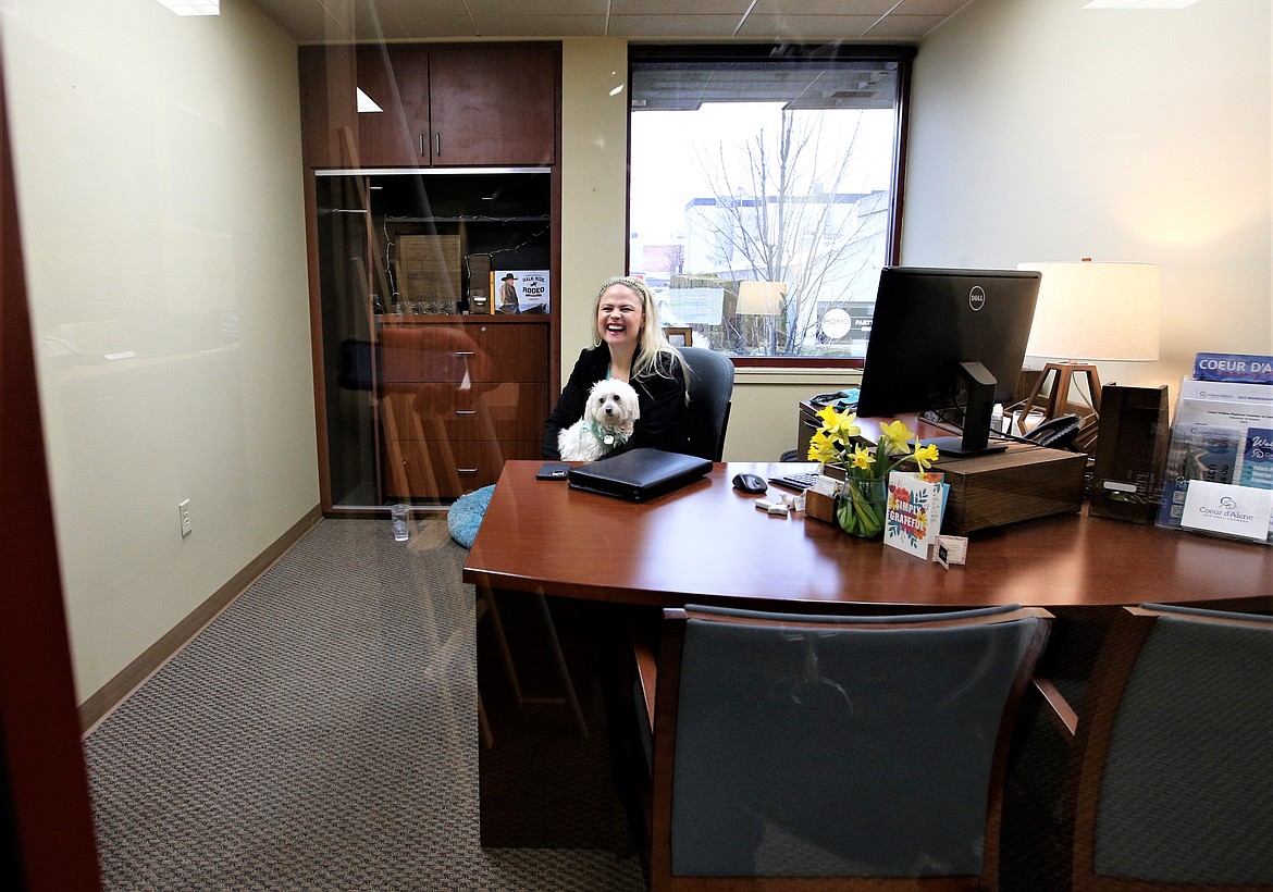 Katie Rose Hargreaves laughs as she holds Pearl, a 14-yer-old Maltese, in her office at the Coeur d'Alene Regional Chamber on Thursday.