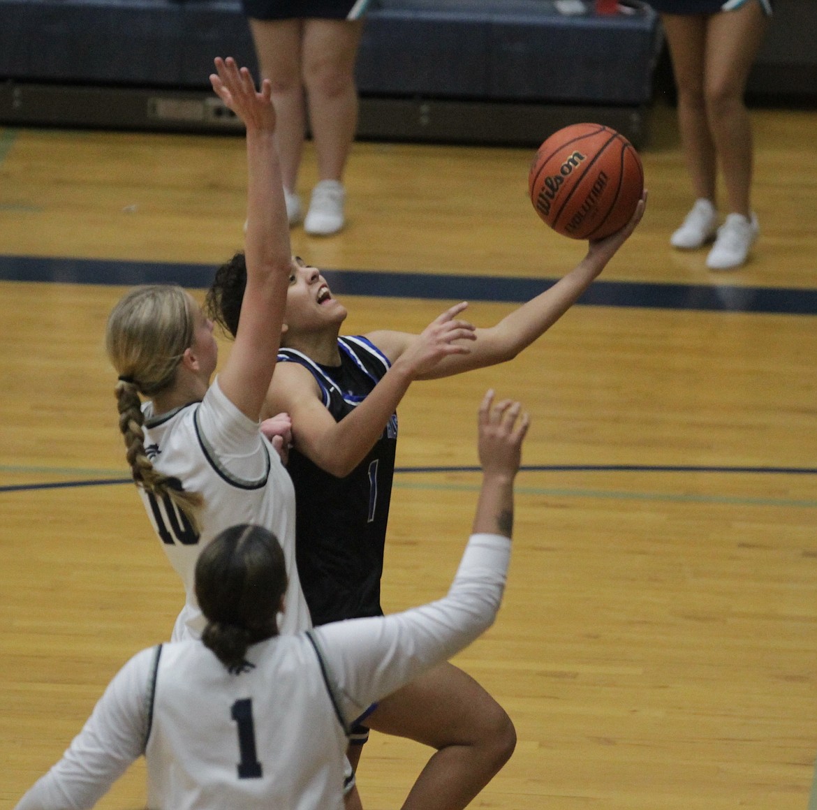 MARK NELKE/Press
Teagan Colvin of Coeur d'Alene glides in for a layup as Avery Waddington of Lake City defends Saturday at Lake City.