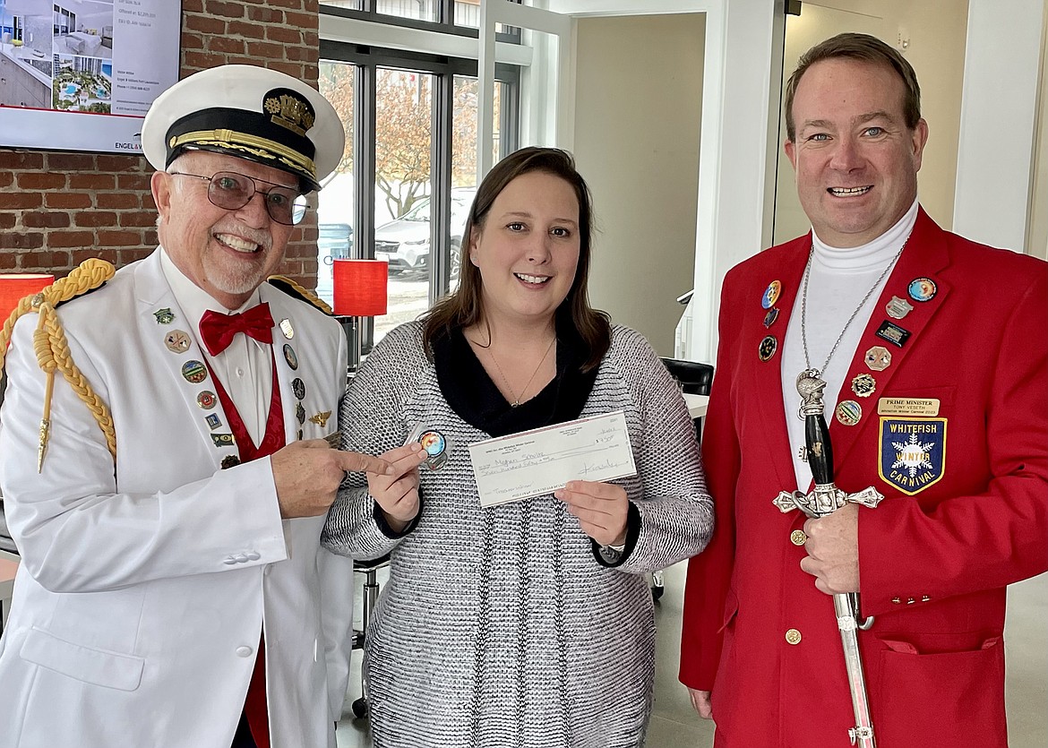 Meghan Schultz, who found the Winter Carnival Treasure along with her husband Steven Dicello and son Jackson Dicello, was presented a check of $750 by King Ullr LXIV Doug Zignego and Prime Minister Tony Veseth last week. (Photo courtesy of Whitefish Winter Carnival)