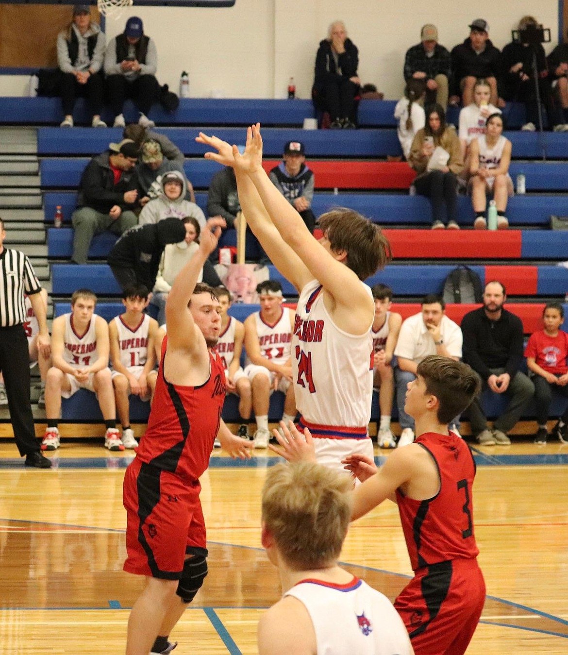 Bobcats senior Orion Plakke (24, white) goes up for a jump shot over Noxon's Sam Christensen (red) during Superior's win over the Red Devils Saturday night in Superior.
(Kami Milender photo)