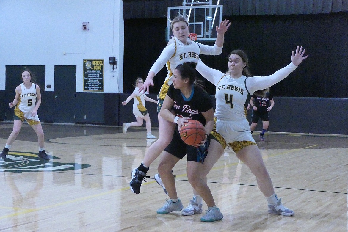 St. Regis players Bailey Hutchinson and Avery Burnham defend against Two Eagle Rivers' Sarah Gardpipe during their game Saturday night in St. Regis.  (Chuck Bandel, VP-MI)