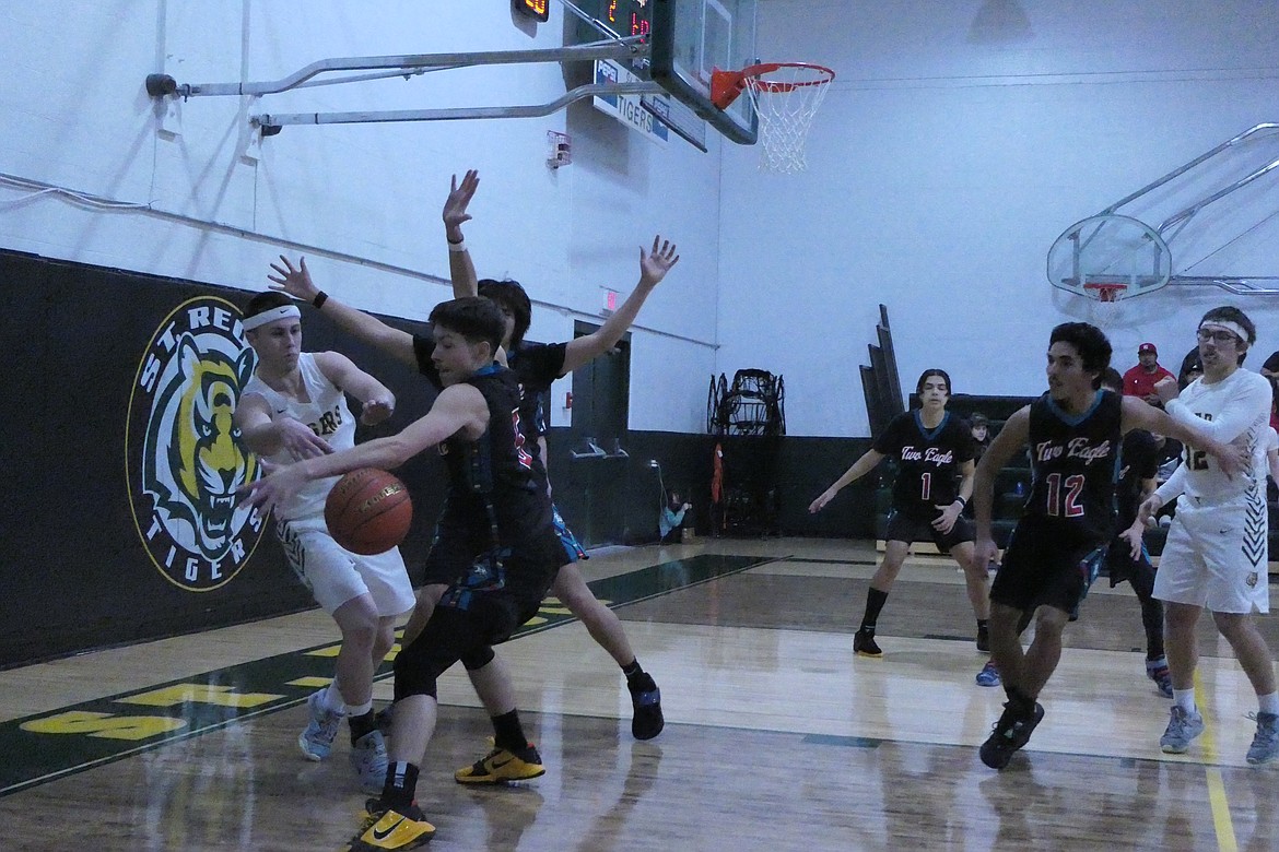 St. Regis senior Caleb Ball (white) is double-teamed by Two Eagle River players as they scramble for control of the ball during Saturday's game in St. Regis.  (Chuck Bandel, VP-MI)